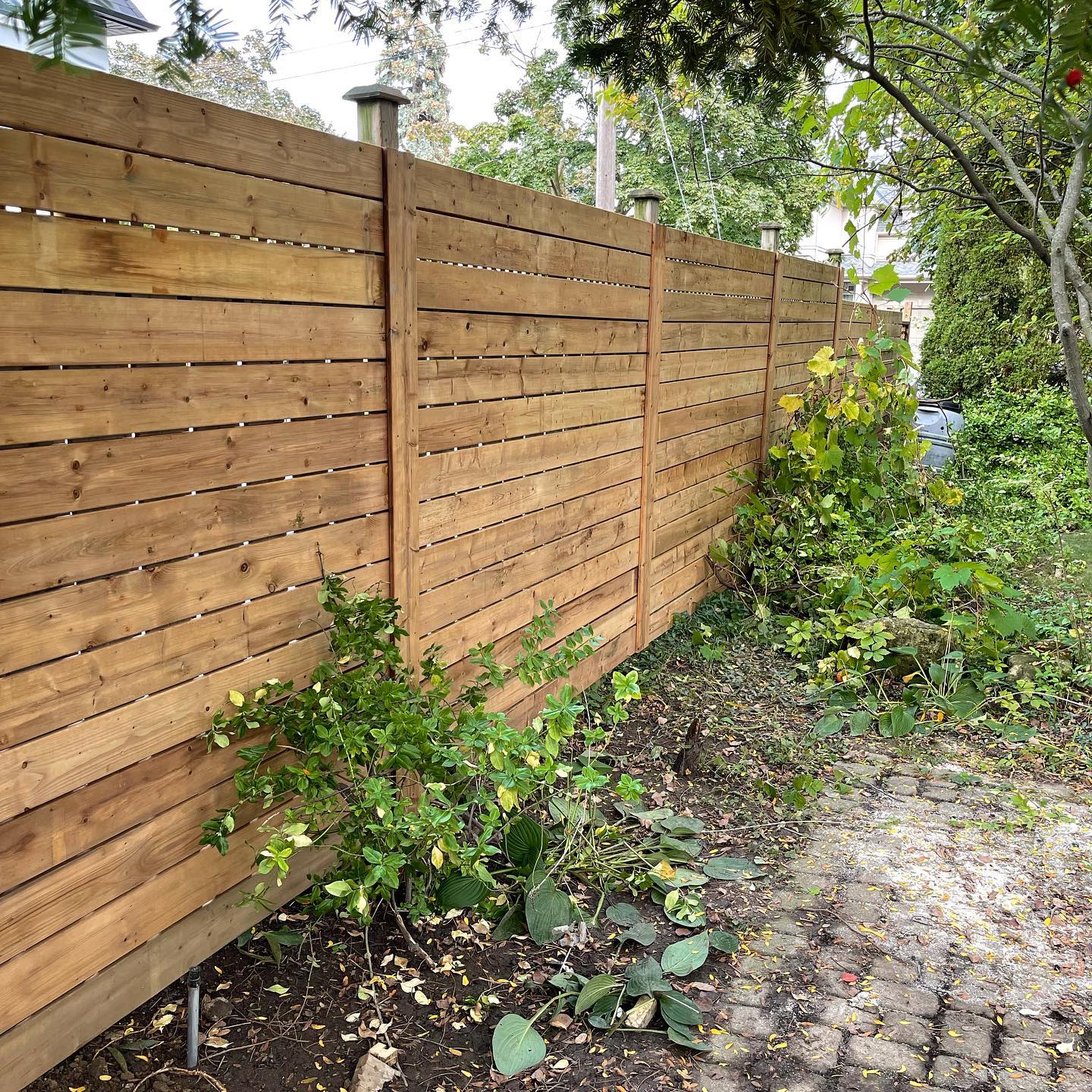 New horizontal wood board fence installed by North Edge Build with even spacing and clean alignment